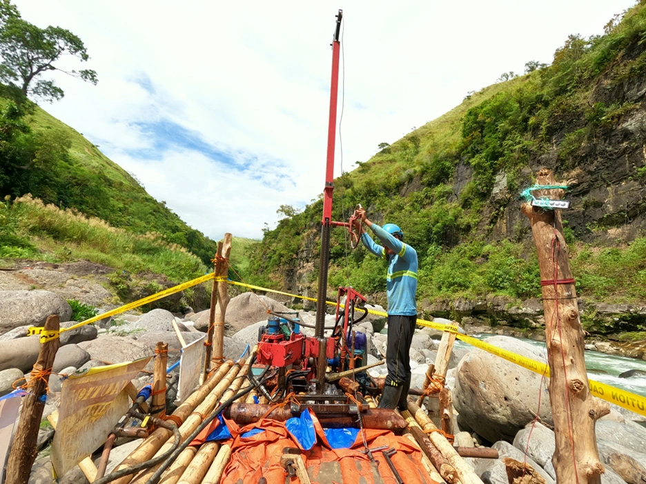 MEGA Philippines crew conducting geotechnical drilling beside a river for a proposed hydroelectric facility